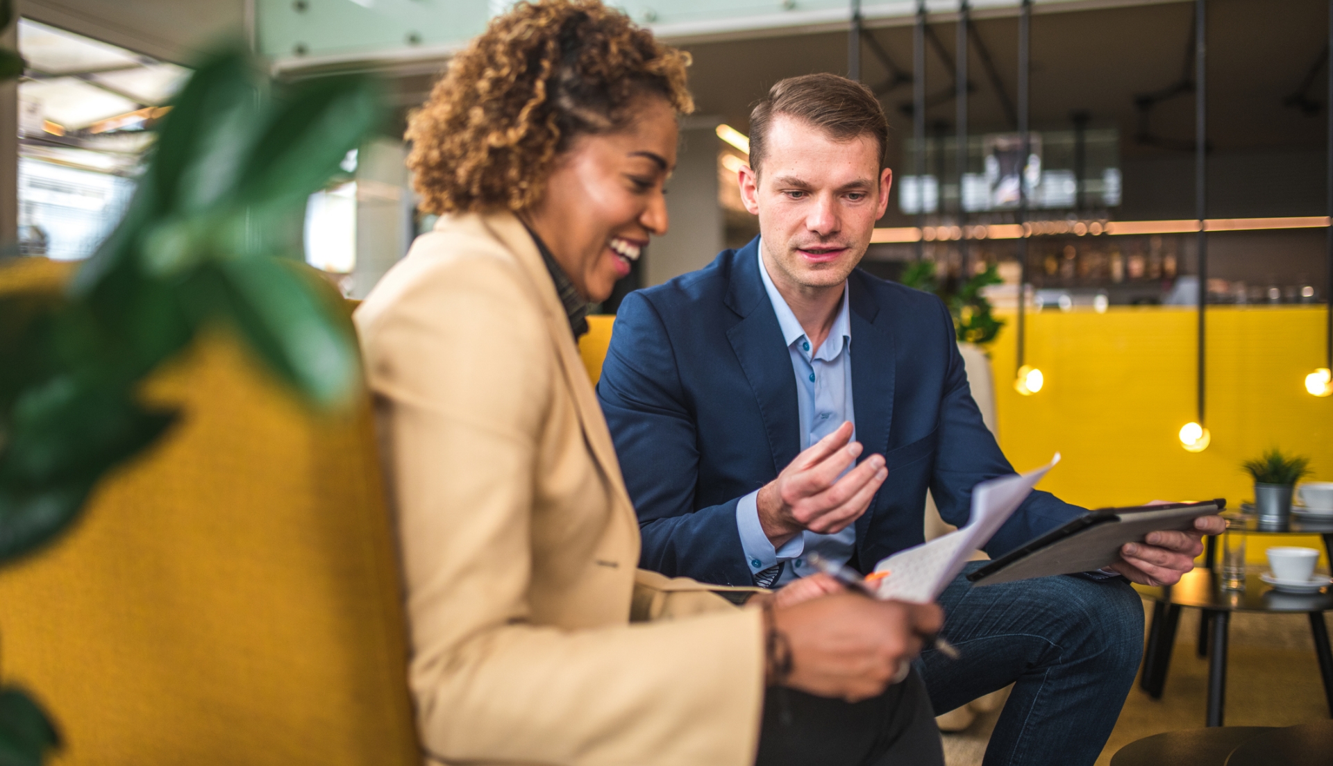 Zwei Mitarbeiter sitzen zusammen und schauen sich Arbeitsunterlagen an