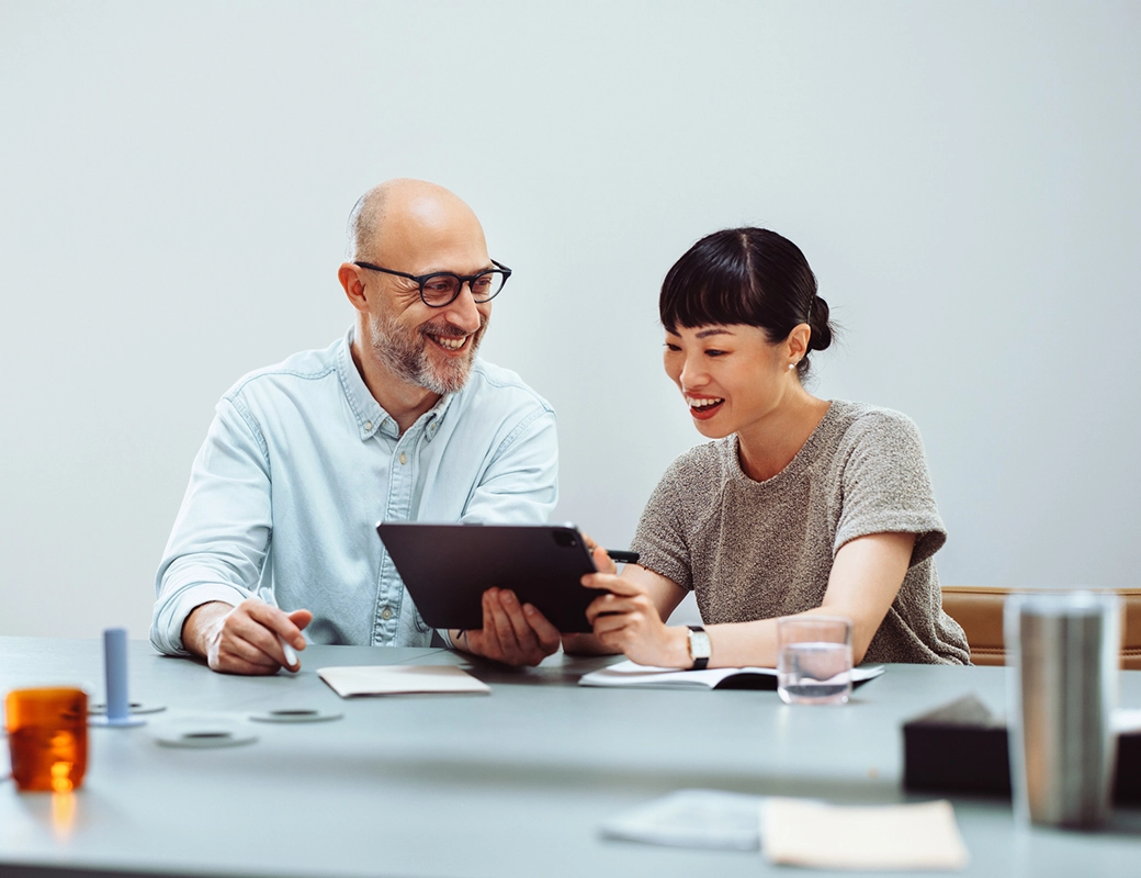 Gebäude aus Stahl und Glas, umgeben von Bäumen und Treppe