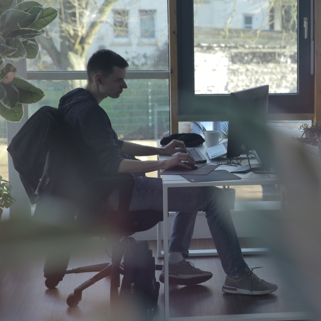 Person arbeitet am Computer für Bau-Lohn für alle Gewerke