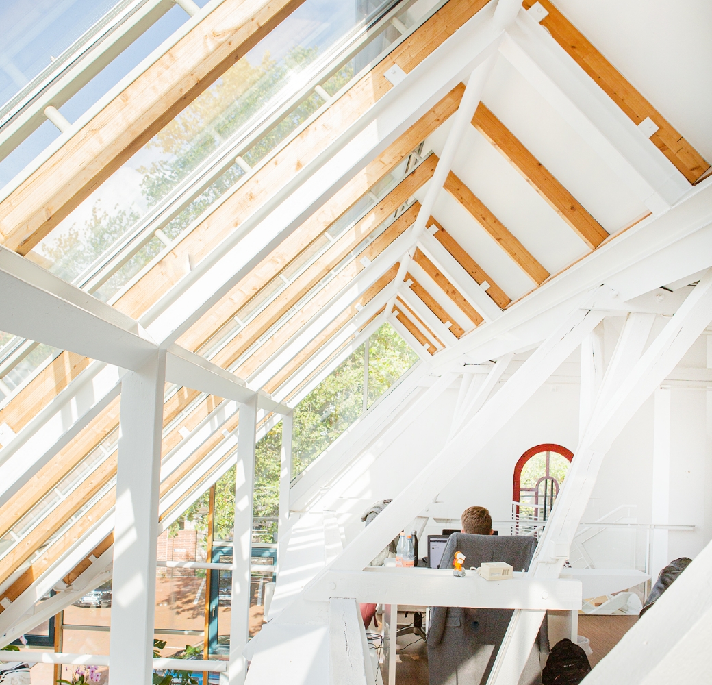 Dachgeschossbüro mit Person, die am Schreibtisch an Bau-Lohn für alle Gewerke arbeitet