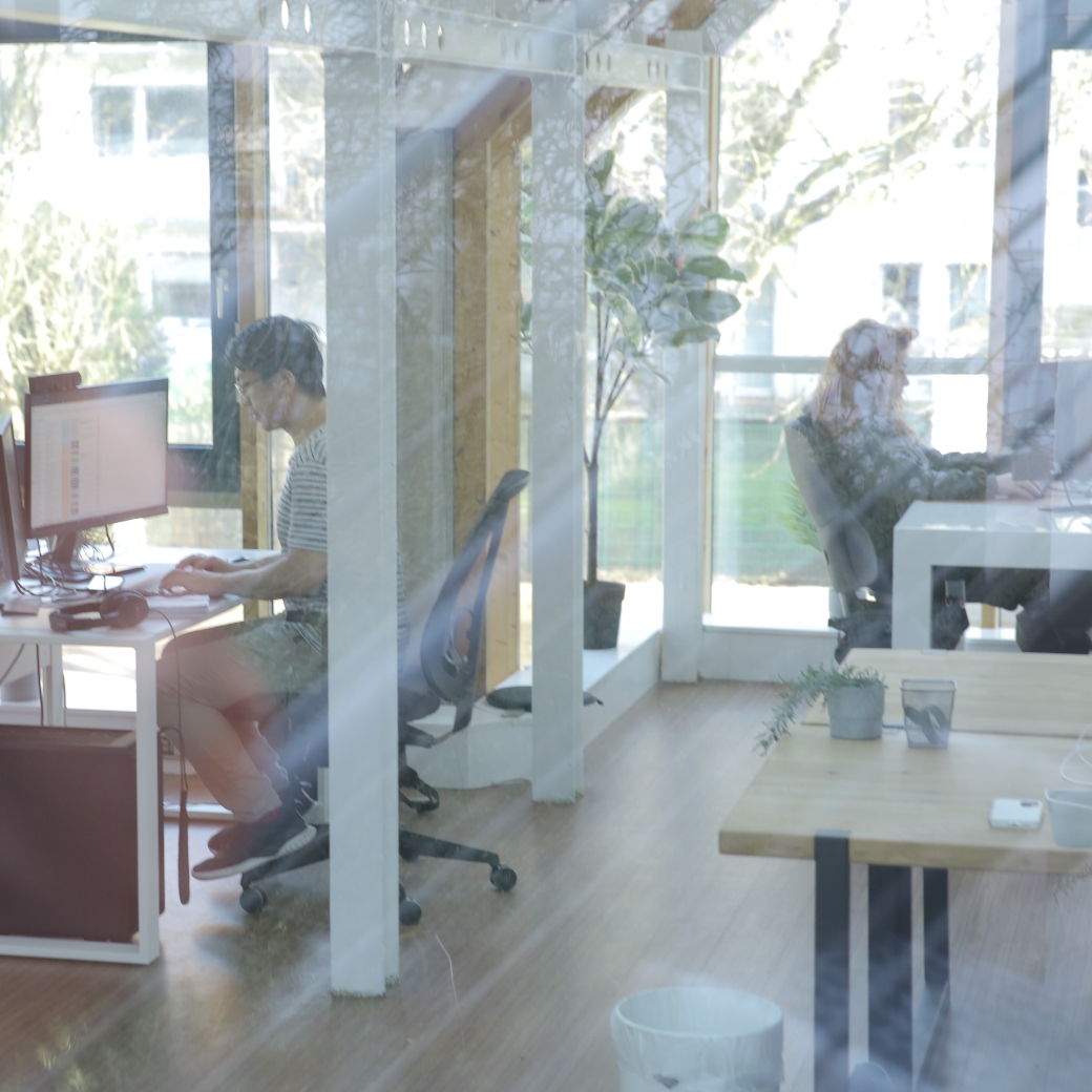 Personen arbeiten an Computern zur digitalen Personalakte in einem lichtdurchfluteten Büro