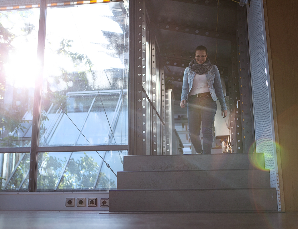 Eine Person geht eine Treppe in hellem Gebäude hinunter