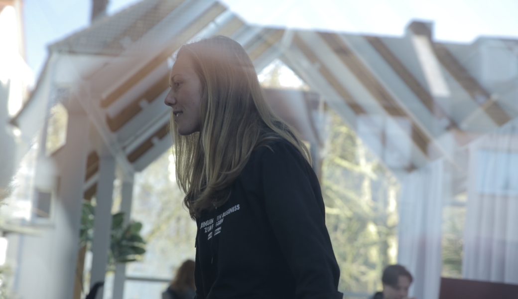 Lächelnde Person bei Tageslicht in einem lichtdurchfluteten Raum.jpg