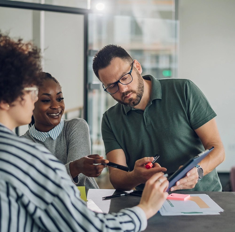 Mann steht am Schreibtisch, betrachtet Bildschirm, modernes Büro