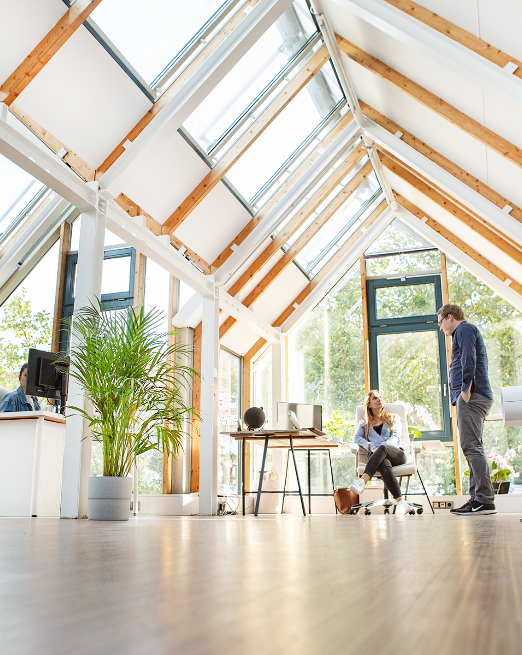 Zwei Personen unterhalten sich in modernem, lichtdurchflutetem Büro
