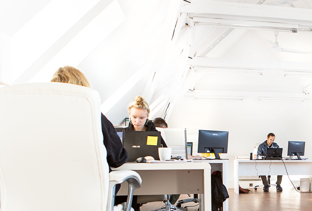 Personen arbeiten konzentriert an Computern in einem hellen Büro