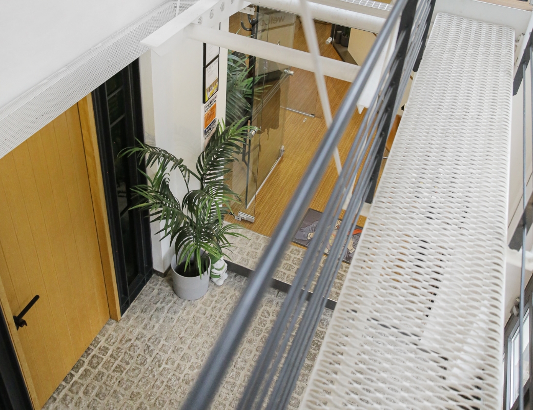 Treppe und Pflanze in modernem Büroflur, Blick von oben