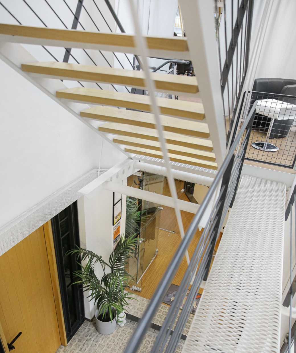 Treppe aus Holz und Metall führt in modernes Büro