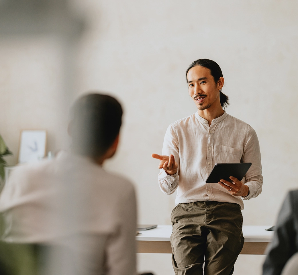 Modernes Gebäude mit Glasfassade neben grünem Baum bei Sonnenschein