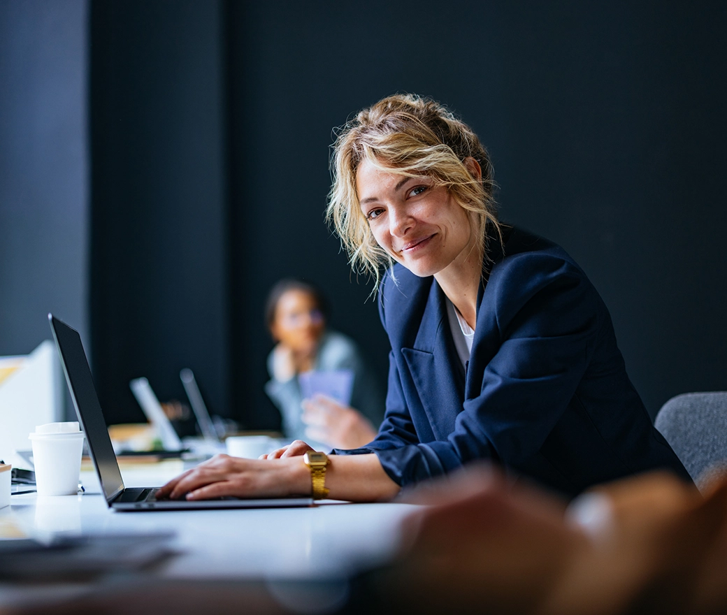Person arbeitet an Computer in einem modernen, lichtdurchfluteten Büro