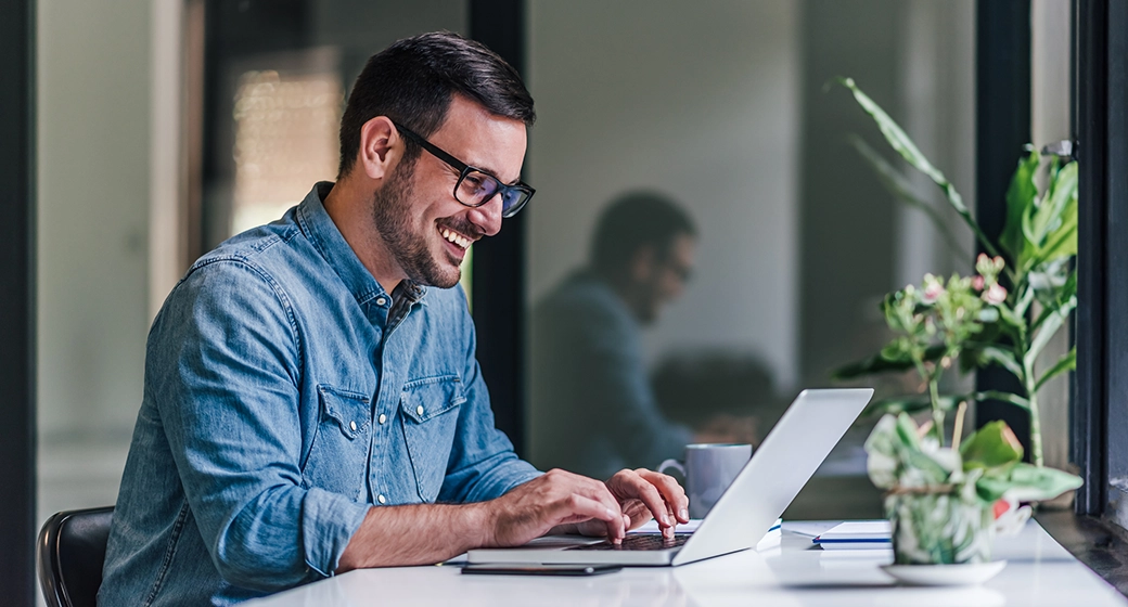Drei Personen unterhalten sich in einem modernen Büro mit Computern