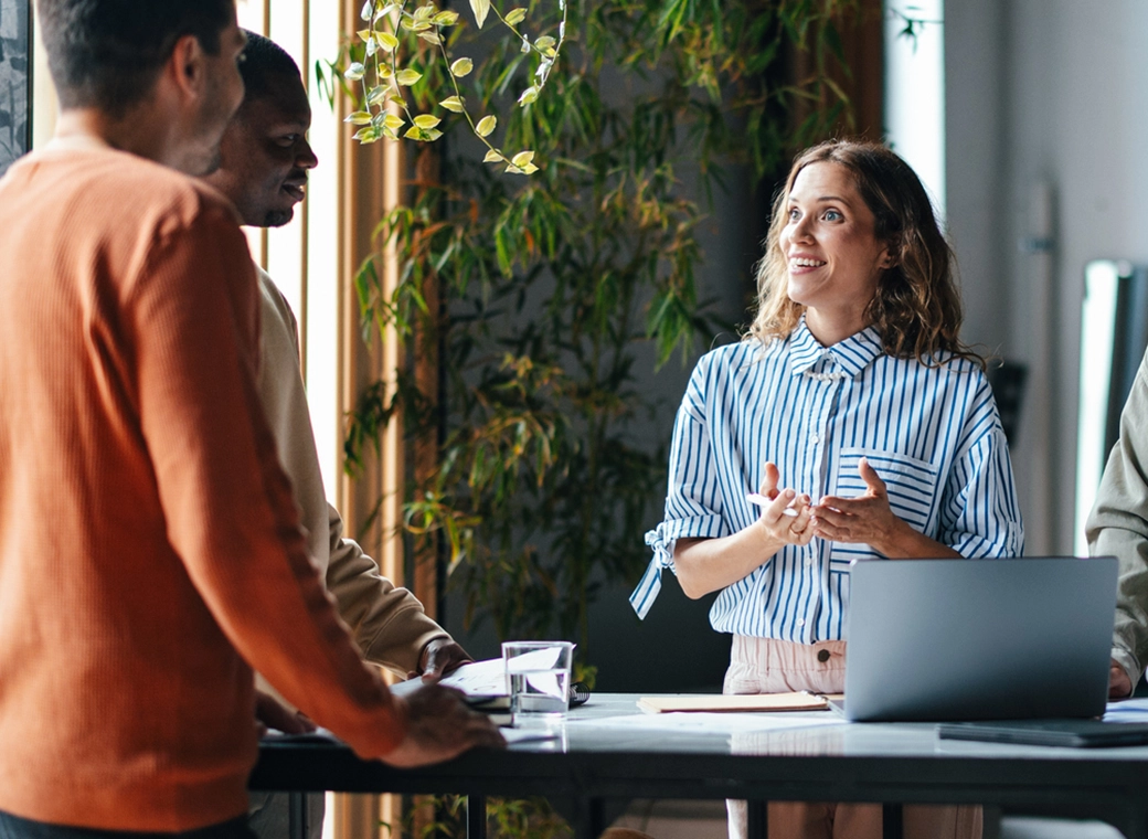 Modernes Glasgebäude reflektiert Bäume unter blauem Himmel