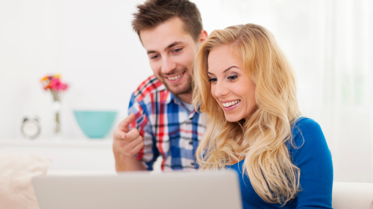 Lohnabrechnung Berlin: Paar lächelt und betrachtet Laptop