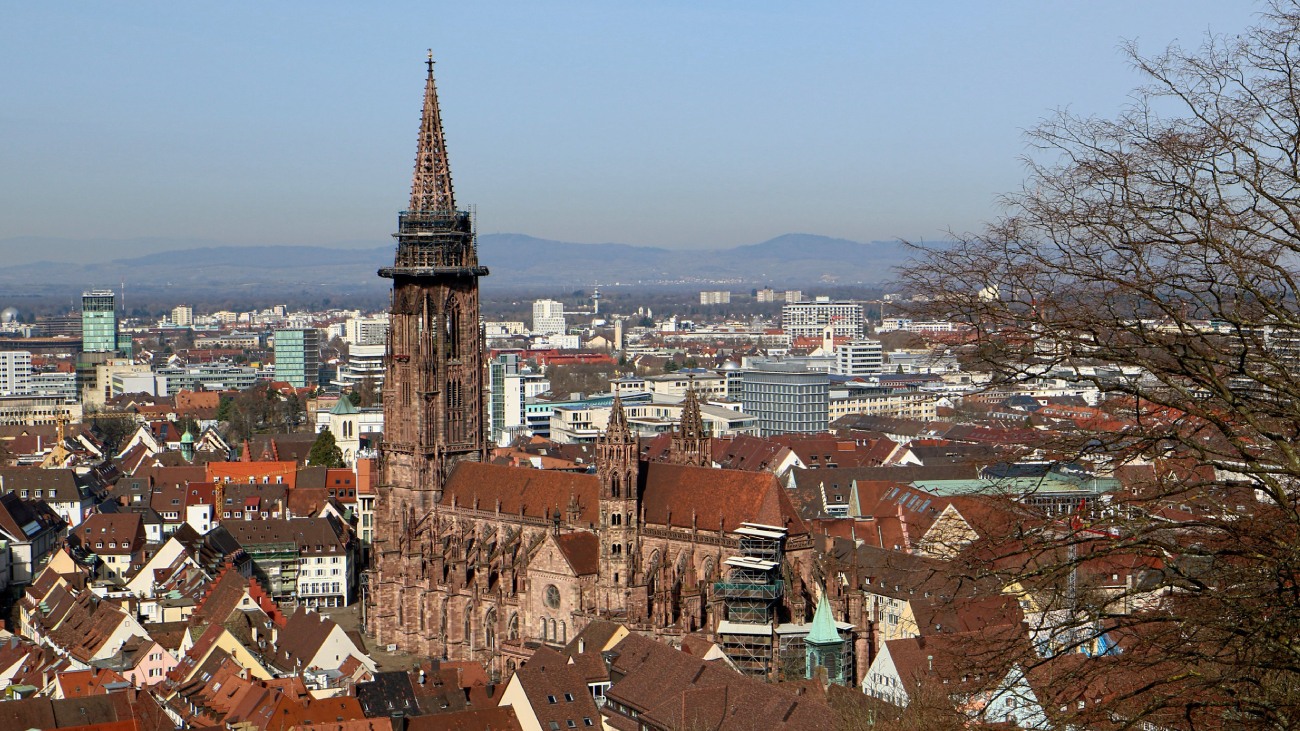 Lohnabrechnung Münster: Kirche überragt Dächer der Stadtlandschaft